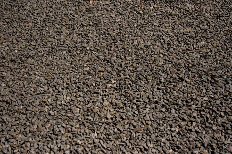 Close-up of different piles of gravel, such as pea gravel, crushed stone, and recycled asphalt, for driveway use.